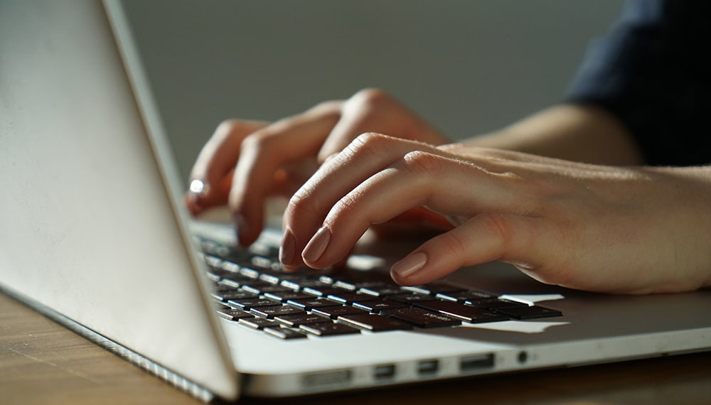 Hands typing on computer