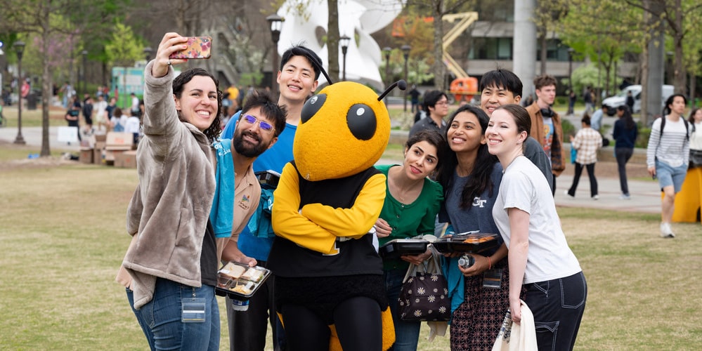Graduate students taking a photo with Buzz mascot at Grad Welcome